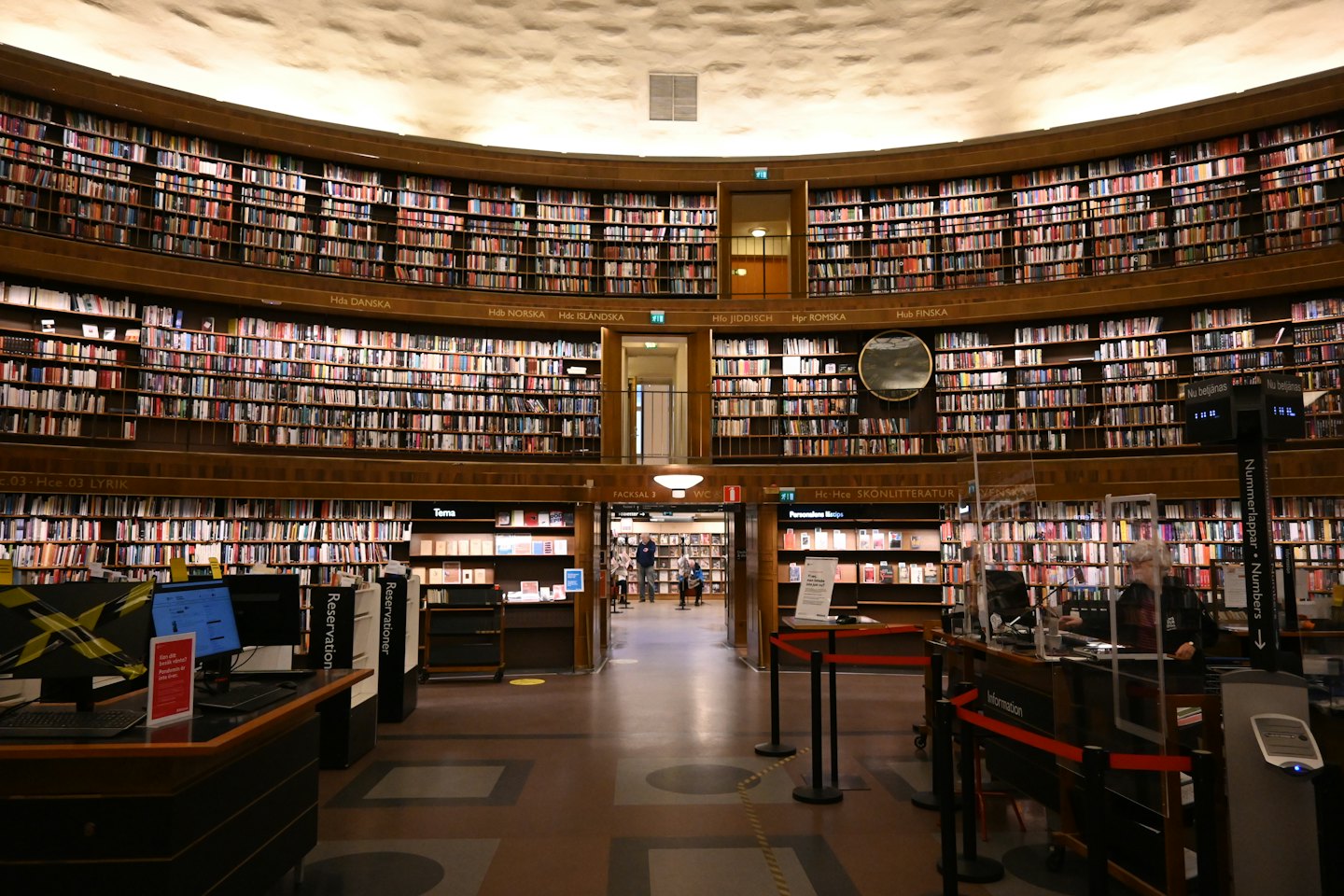 Patrons and staff work inside a grand circular library.